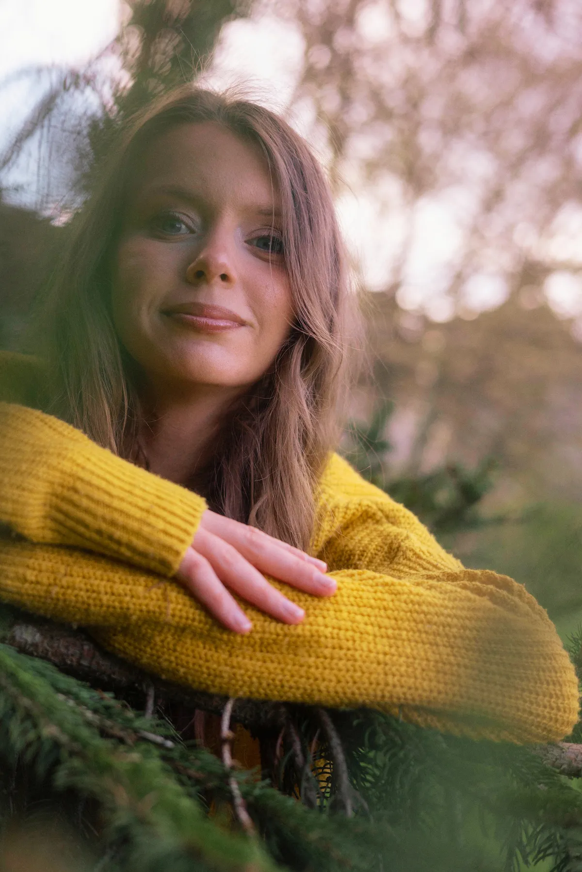 Portrait d’une jeune femme en pull jaune dans la nature